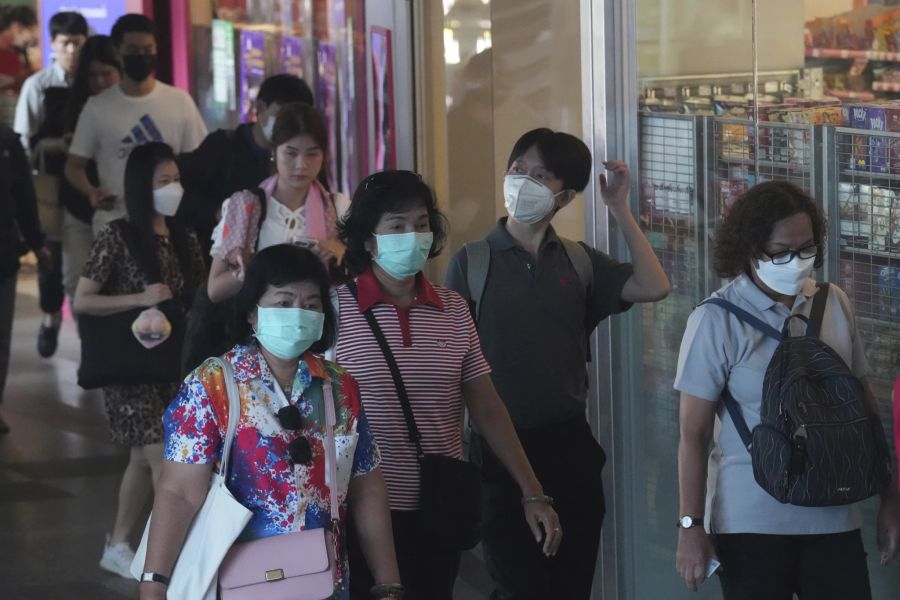 Pendler tragen Gesichtsmasken in einer Skytrain-Station in Bangkok.