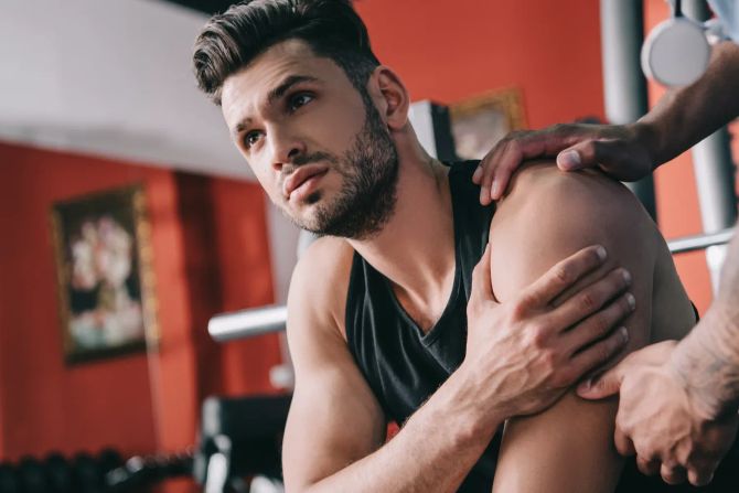 Mann beim Fitness mit Sportverletzung an der Schulter