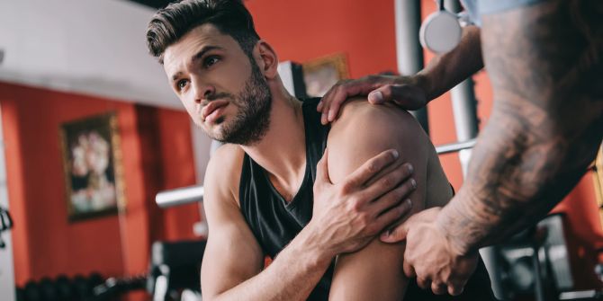 Mann beim Fitness mit Sportverletzung an der Schulter