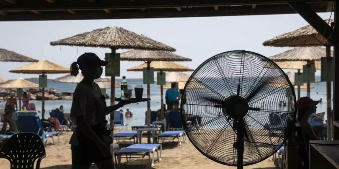 Eine Kellnerin serviert Erfrischungen in einer Strandbar in Griechenland. Foto: Yorgos Karahalis/AP/dpa Eine Kellnerin serviert Erfrischungen in einer Strandbar in Griechenland. Foto: Yorgos Karahalis/AP/dpa