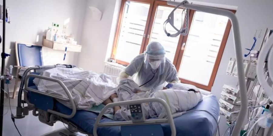 Ein Intensivpfleger arbeitet auf der Intensivstation des Krankenhauses Bethel in Berlin an einer Corona-Patientin. Foto: Kay Nietfeld/dpa