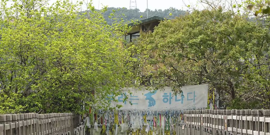Ein Banner und Bänder, die hoffnungsvolle Botschaften über eine erwünschte Wiedervereinigung der beiden Koreas zeigen, sind am Drahtzaun des Imjingak-Pavillons nahe der Grenze zu Nordkorea zu sehen. Foto: Ahn Young-Joon/AP/dpa
