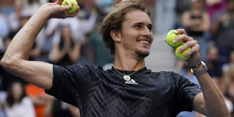 Alexander Zverev wirft nach seinem Viertelfinalsieg bei den US Open Tennisbälle ins Publikum. Foto: Elise Amendola/AP/dpa