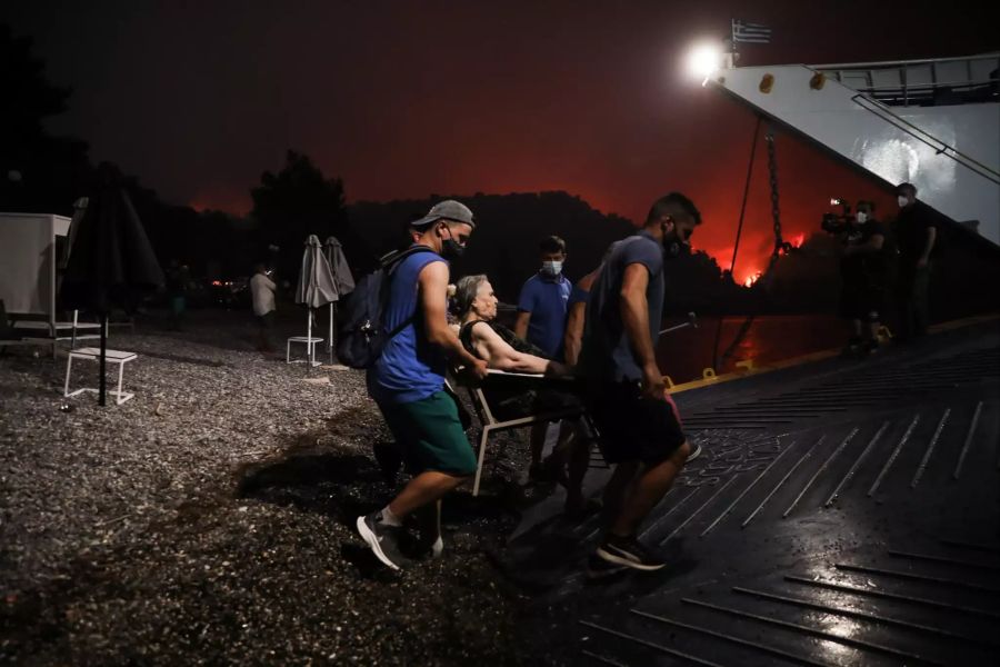 Menschen steigen auf eine Fähre in Euböa, die sie von der Insel evakuiert.