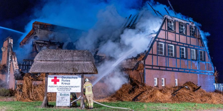 Feuerwehrleute löschen den Brand in einem mecklenburgischen Hotel, in dem Geflüchtete aus der Ukraine untergebracht waren.
