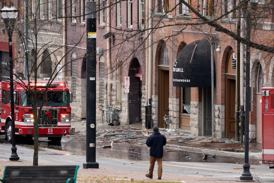 25.12.2020, USA, Nashville: Eine Person geht am Ort einer heftigen Explosion in der Innenstadt entlang.  Foto: Mark Humphrey