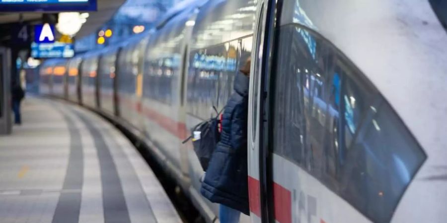 Ein Fahrgast steigt in einen Fernzug der Deutschen Bahn. Die EVG spricht sich gegen eine Reservierungspflicht in Zügen aus. Foto: Friso Gentsch/dpa