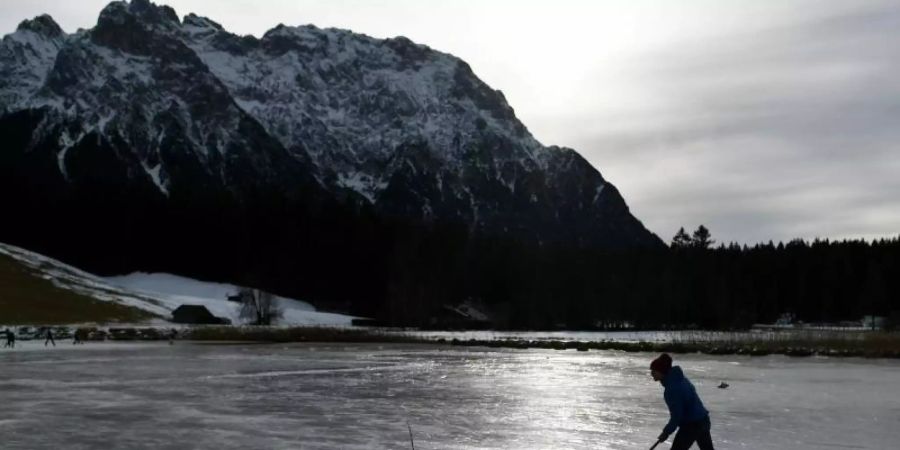Eisläufer nutzen das Eis auf dem Schmalensee bei Mittenwald ganz im Süden Bayerns. Nicht nur an den Alpen, auch in den südlichen und östlichen Mittelgebirgen gibt es Chancen für die Bildung einer Schneedecke. Foto: Angelika Warmuth/dpa