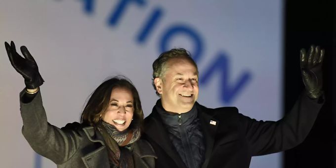 Kamala Harris, «Gewählte Vizepräsidentin» («Vicepresident-elect»), und ihr Ehemann Doug Emhoff winken Unterstützern während einer Wahlkampfveranstaltung (Archiv). Foto: Michael Perez/AP/dpa Kamala Harris