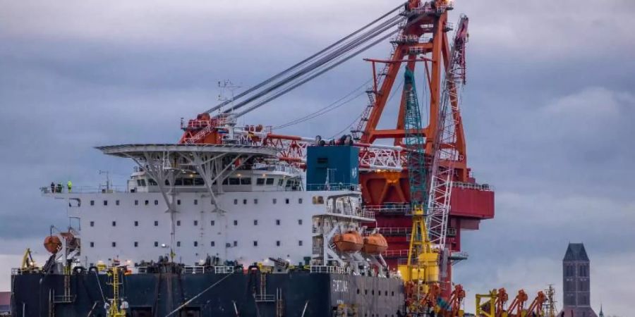 Schlepper ziehen das russische Rohr-Verlegeschiff «Fortuna» aus dem Hafen auf die Ostsee. Foto: Jens Büttner/dpa-Zentralbild/ZB