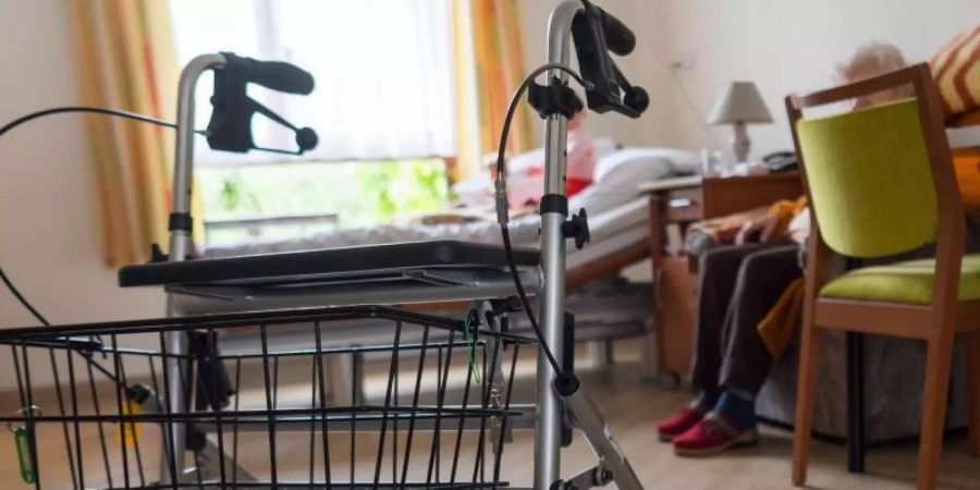 Ein Rollator steht im Zimmer einer älteren Frau. Foto: Monika Skolimowska/zb/dpa