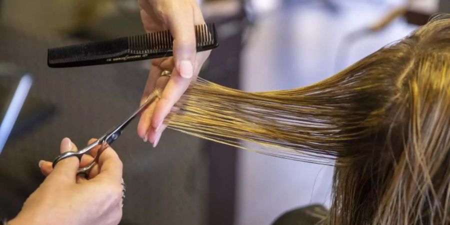 Das Risiko für eine Ansteckung mit dem Coronavirus ist laut einer neuen Untersuchung beim Friseur vergleichsweise gering. Foto: Nicolas Maeterlinck/BELGA/dpa