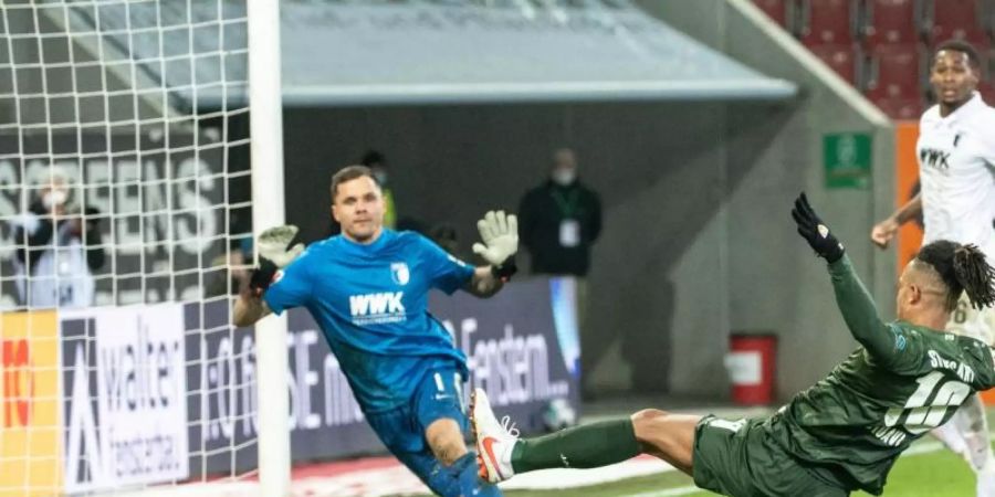 Daniel Didavi vom VfB Stuttgart setzt zum Torschuss an und trifft. Torwart Rafal Gikiewicz vom FC Augsburg kann den Ball nicht abwehren. Foto: Matthias Balk/dpa