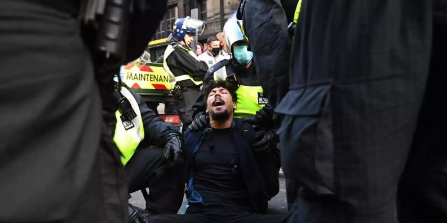 Die Polizei verhaftet einen Demonstranten. Foto: Victoria Jones/PA Wire/dpa