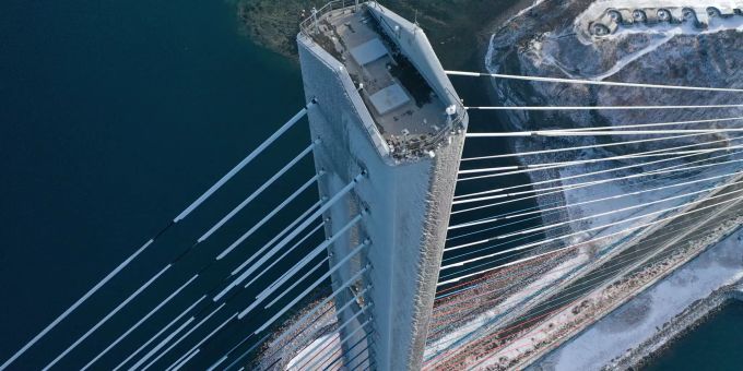 24.11.2020, Russland, Wladiwostok: Die Russki-Brücke über den östlichen Bosporus, die die Russki-Insel mit dem Festland von Wladiwostok verbindet. Die Brücke ist für den Verkehr gesperrt, weil Eisbrocken von den Kabeln auf der Fahrbahn gefallen waren. Nach einem eisigen und schneereichen Wirbelsturm sind knapp 60.000 Menschen in der russischen Region Primorje am Pazifik ohne Strom. Mehr als 19.000 Menschen seien ausserdem rund eine Woche nach dem Unwetter weiter ohne Heizung, teilte das russische Energieministerium mit - bei minus zwei Grad Aussentemperatur. Foto: Viktor Gokhovich/TASS/dpa +++ dpa-Bildfunk +++ Nach Wirbelsturm: Zehntausende in Russland ohne Strom und Heizung