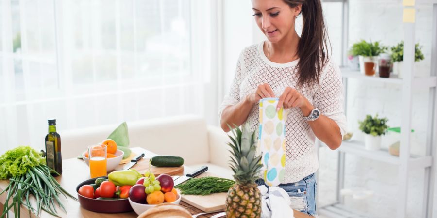 Frau mit Obst und Gemüse in Küche