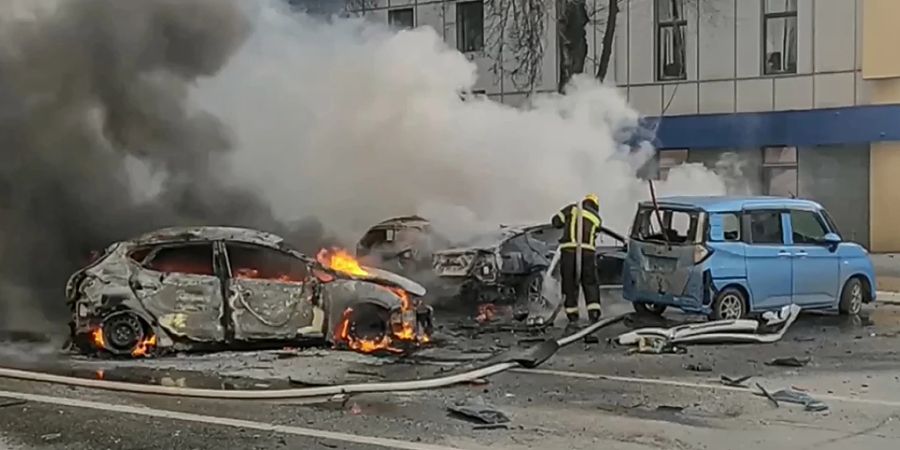 Feuerwehrleute löschen brennende Autos in Belgorod. Foto: Uncredited/Russia Emergency Situations Ministry telegram channel/AP/dpa - ACHTUNG: Nur zur redaktionellen Verwendung und nur mit vollständiger Nennung des vorstehenden Credits