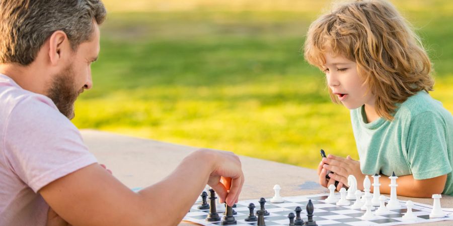 Vater und Kind spielen Schach