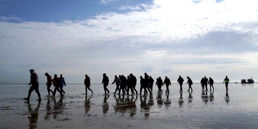 Mutmassliche Migranten bei Dungeness, nachdem sie nach einem Zwischenfall mit einem kleinen Boot im Ärmelkanal mit einem Rettungsboot der Royal National Lifeboat Institution (RNLI) an Land gebracht wurden.