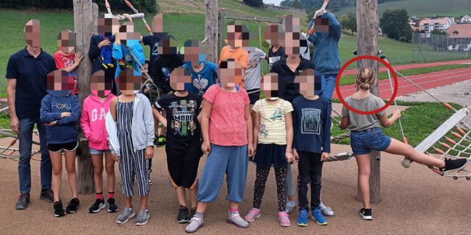 Ein Kind dreht der Kamera auf dem Klassenfoto den Rücken zu. Schule