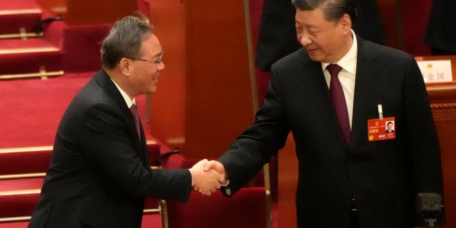 Xi Jinping (r), Chinas Staats- und Parteichef, wird von Li Qiang beglückwünscht, nachdem er erneut einstimmig zum Präsidenten gewählt wurde.