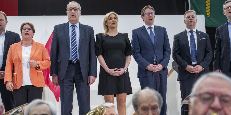 Magdalena Martullo-Blocher, Nationalrätin, Guy Parmelin, Bundesrat, Vorsteher des EFD, Celine Amaudruz, Präsidentin der SVP Genf, Albert Roesti, Mitglied des Bundesrates, Marco Chiesa, Ständerat, Präsident der SVP Schweiz, von links nach rechts, singen die Schweizer Nationalhymne an der Delegiertenversammlung der Schweizerischen Volkspartei SVP am Samstag, 18. März 2023, in Meyrin bei Genf.