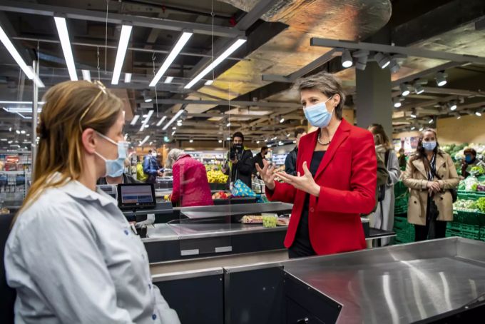 Bundesrätin Simonetta Sommaruga spricht mit einer maskentragenden Coop-Kassiererin. (Archivbild) Corona