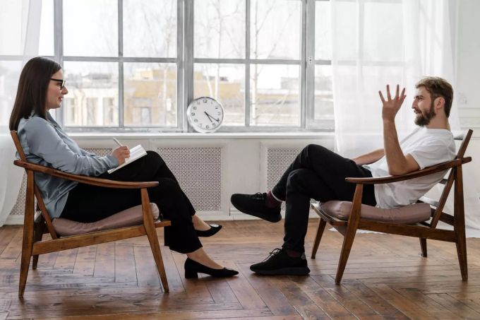 Eine Therapie kann bei seelischen Belastungen helfen. Therapeutin mit Patient