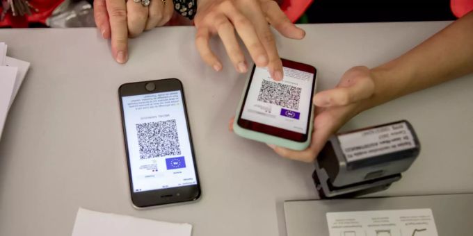 Zwei Mitarbeiterinnen des Roten Kreuzes helfen in Le Bourget (F) einem Mann, den Gesundheitspass auf dem Mobiltelefon zu aktivieren. (Archivbild) Gesundheitspass Frankreich
