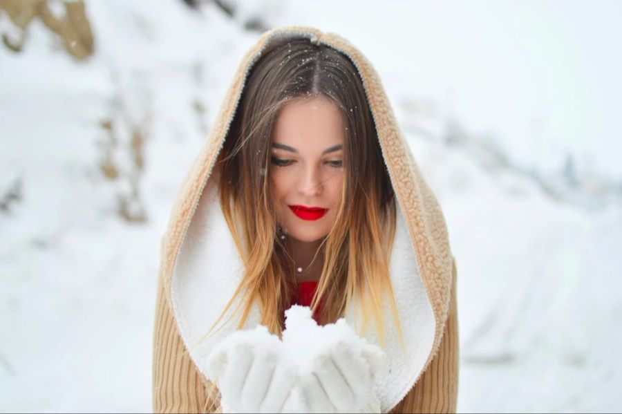 Frau hält Schnee in Hand