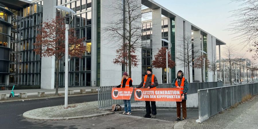 Aktivisten der Klimaschutzgruppe «Letzte Generation» blockieren am frühen Morgen eine Zufahrt zur Tiefgarage des Bundestages.