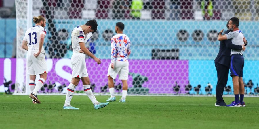 Spieler aus den USA stehen nach dem Spiel enttäuscht auf dem Spielfeld.