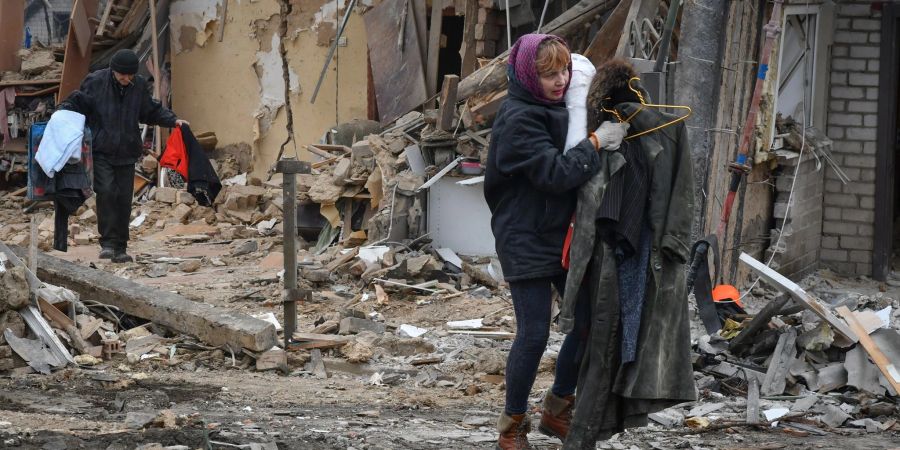 Anwohner tragen in Saporischschja ihre Habseligkeiten aus von Bomben zerstörten Häusern.