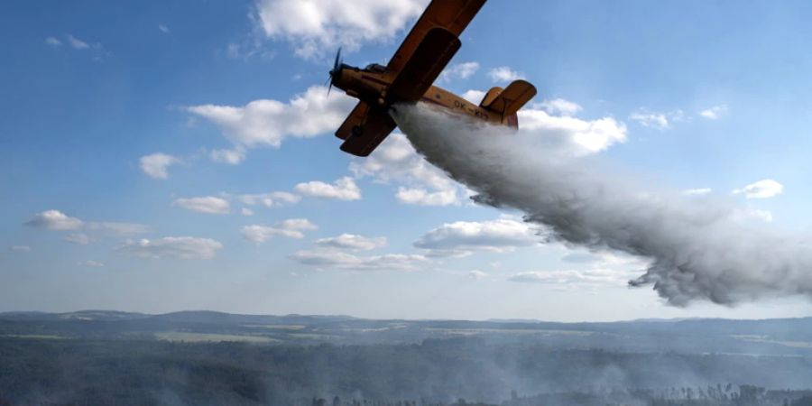 Feuerwehrleute bekämpfen einen Waldbrand in der Nähe des tschechischen Dorfs Hrensko mit einem Flugzeug. (Archivbild)