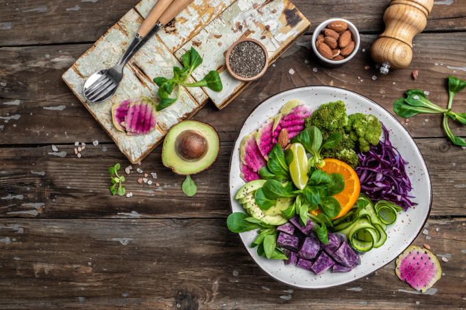 Bei einer rein pflanzlichen Ernährungsweise sollte der Essensplan Abwechslung bieten, um den Körper um mit Omega-3-Fettsäuren zu versorgen. Obst- und Gemüseteller, vegan