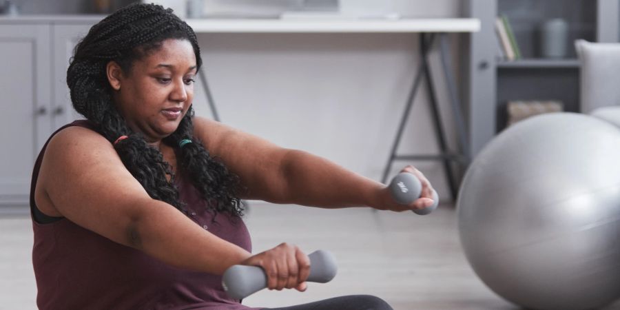 schwarze frau macht yoga, hanteln, weisser hintergrund