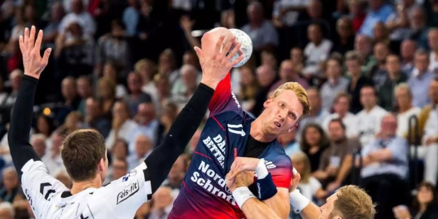 Die Kieler Hendrik Pekeler (l) und Steffen Weinhold (r) verteidigen am Wurfkreis gegen Simon Jeppsson von der SG Flensburg-Handewitt. Foto: Benjamin Nolte
