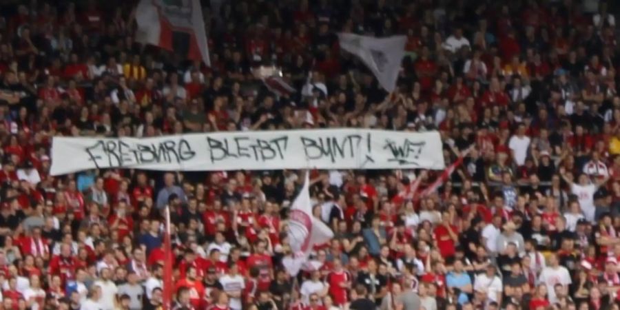 Anhänger halten einen Banner mit «Freiburg bleibt bunt» in die Höhe.