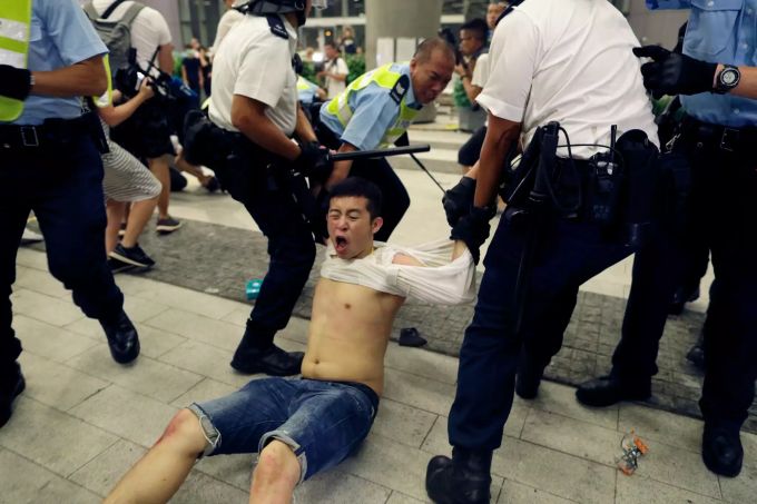Polizisten ziehen einen Demonstranten weg, der an einem Protest gegen das von der Regierung geplante Auslieferungsgesetz teilgenommen hat. hongkong