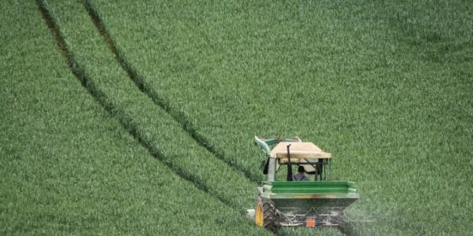 Ein Traktor mit Düngerstreuer. pestizid