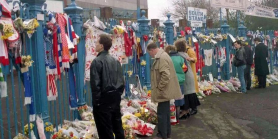 Fussballfans gedenken am 15. April 2019 vor dem Stadion am 30. Jahrestag der Opfer der Hillsborough-Tragödie. Foto: Peter Kemp
