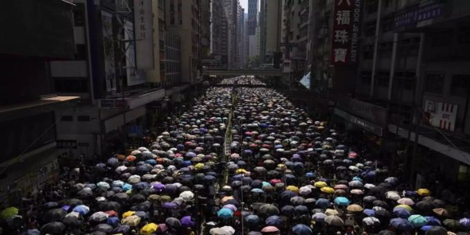 Tausende Hongkonger ziehen mit Regenschirmen über eine Strasse. Foto: Vincent Yu/AP Tausende Hongkonger ziehen mit Regenschirmen über eine Strasse. Foto: Vincent Yu/AP