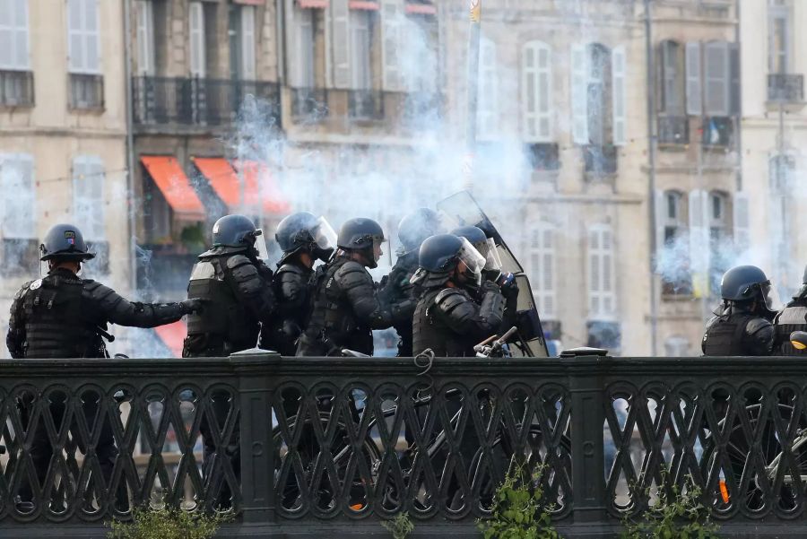 Polizisten schützen sich vor Demonstranten bei einem Protest gegen den G7-Gipfel.