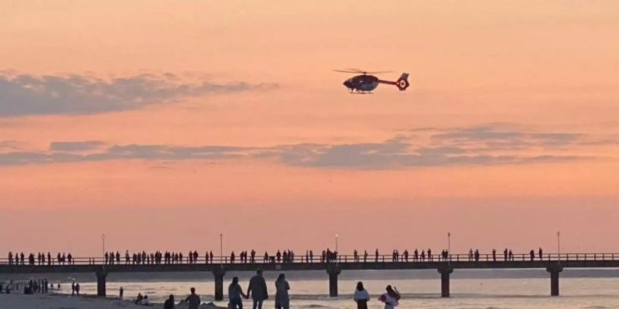 Rettungshubschrauber über der Seebrücke im Ostseebad Zinnowitz. Foto: Tilo Wallrodt/dpa