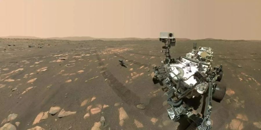 Dieses Handout der US-Raumfahrtbehörde Nasa zeigt den US-Rover «Perseverance» (r) neben dem Mini-Hubschrauber «Ingenuity» (M) auf dem Mars. Foto: --/NASA/JPL-Caltech/MSSS/dpa