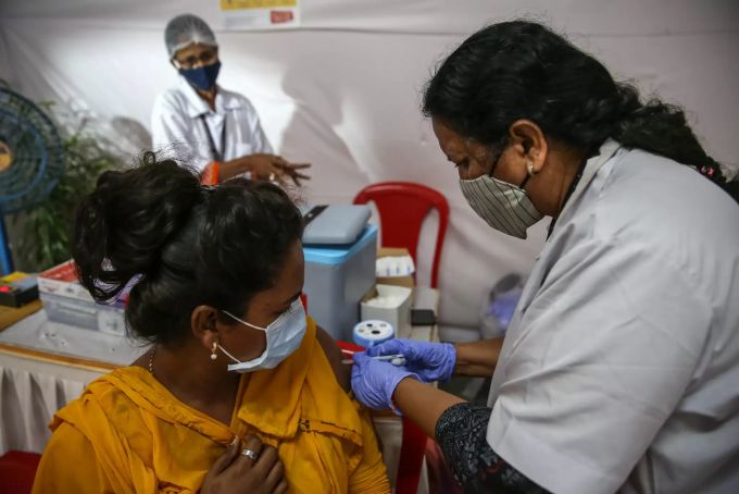 Eine Frau in Mumbai, Indien wird gegen Corona geimpft. Indien Corona