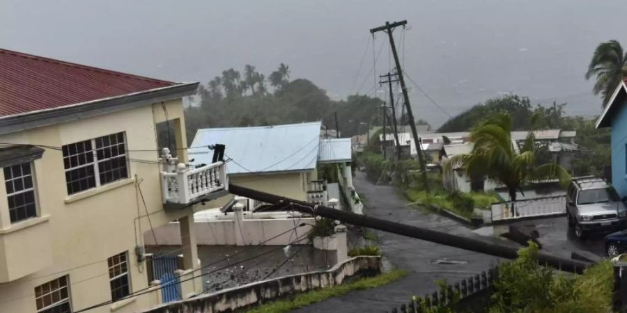 Infolge von Hurrikan «Elsa» ist ein Strommast auf ein Gebäude in Cedar Hills, St. Vincent, gestürzt. Foto: Orvil Samuel/AP/dpa