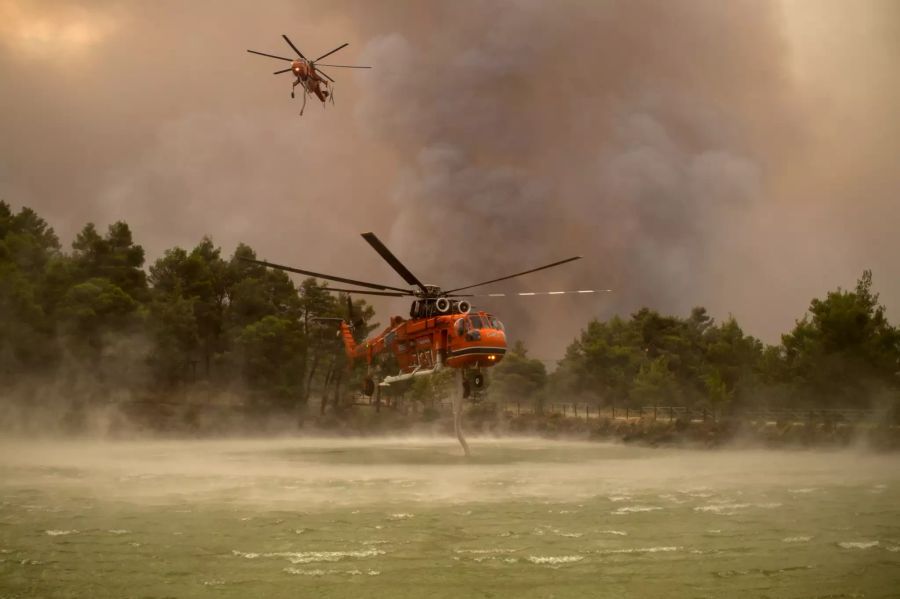 Löschhubschrauber werden während eines Waldbrandes nördlich von Athen mit Wasser aus dem Beletsi-See befüllt.