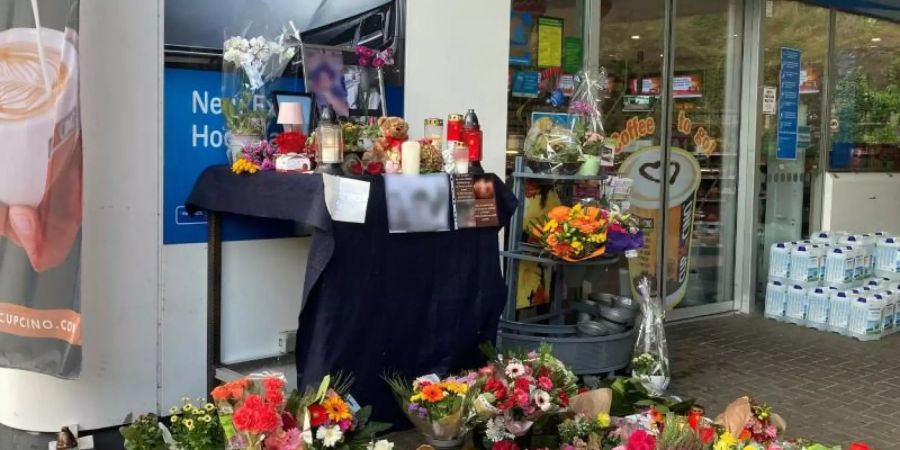 Blumen und Kerzen sind vor der Aral-Tankstelle in Idar-Oberstein aufgestellt.