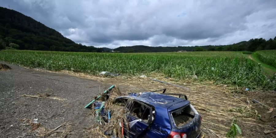 Zerstörtes Auto auf einem Feld im Flutgebiet